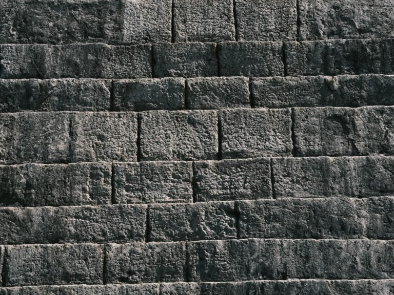 Close-up of a textured stone wall with natural light highlighting rough surfaces.