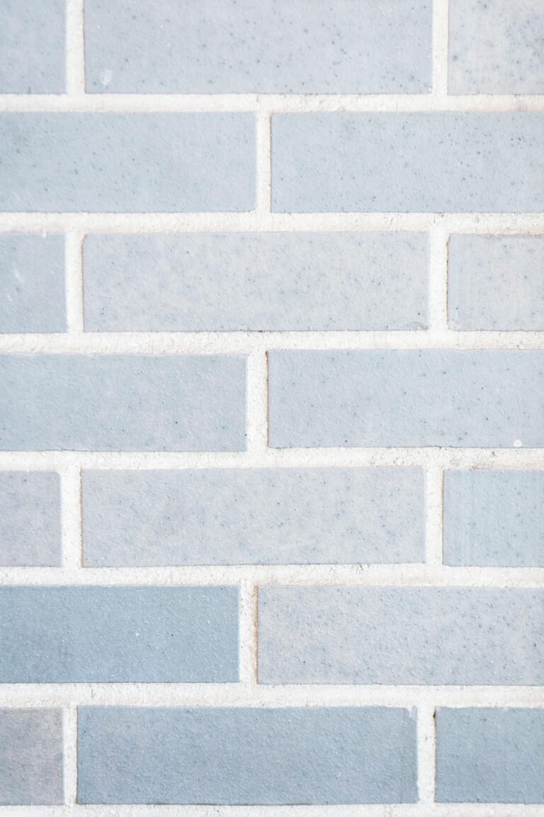 Full frame minimalist background of light gray wall with rows of bricks on wall